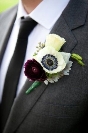Boutonnieres of cream and deep red flowers